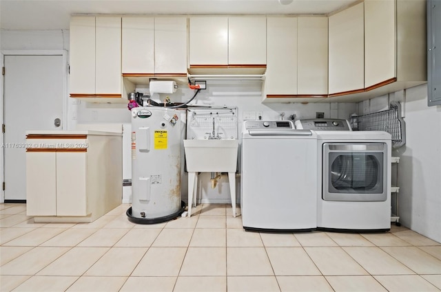 clothes washing area featuring washer and dryer, cabinet space, water heater, and light tile patterned floors