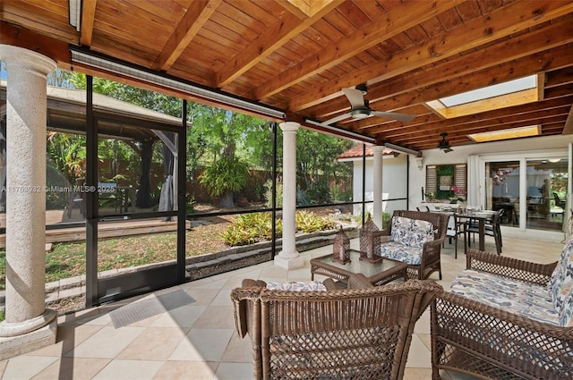 sunroom with beam ceiling, wooden ceiling, decorative columns, and ceiling fan