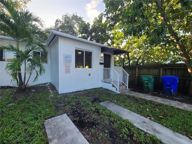 view of front of property with stucco siding and fence