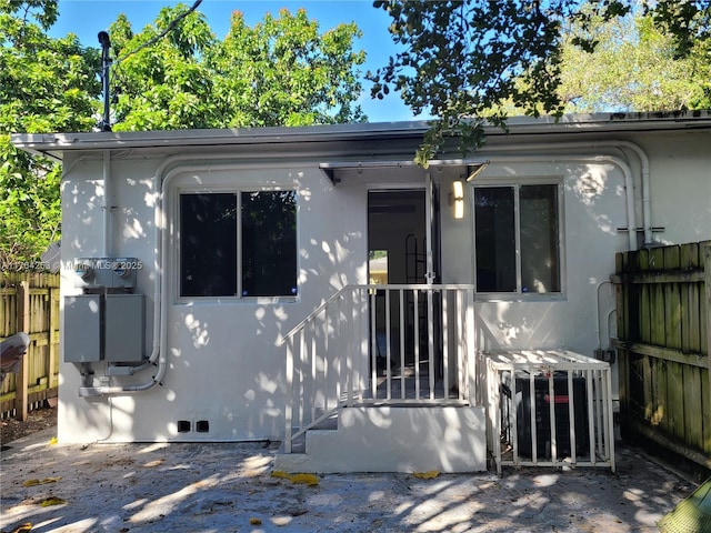 view of front facade featuring stucco siding and fence