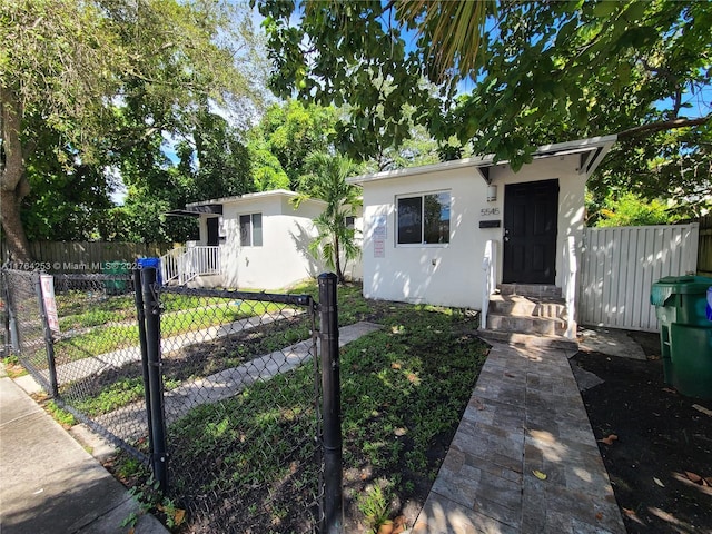 view of front of home featuring stucco siding and fence private yard
