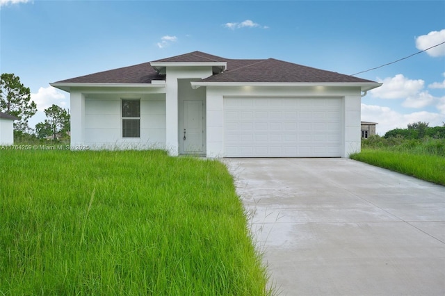 prairie-style home with concrete driveway, an attached garage, roof with shingles, and stucco siding