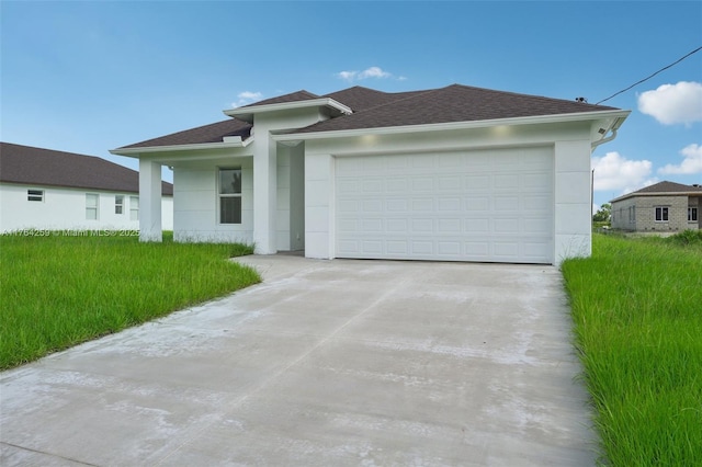 prairie-style house with roof with shingles, driveway, stucco siding, a front lawn, and a garage