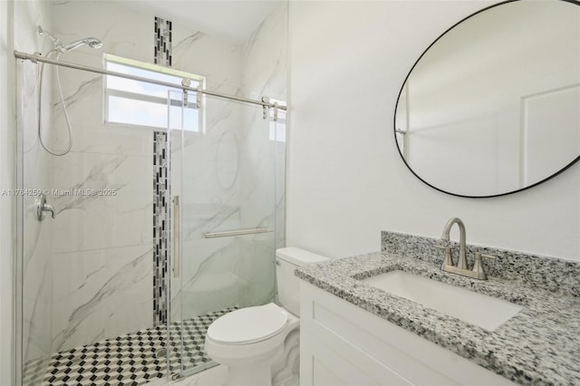 full bathroom featuring a marble finish shower, toilet, and vanity