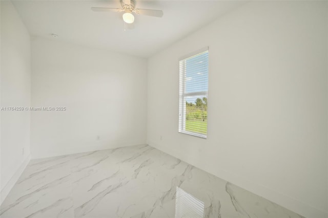 unfurnished room with a ceiling fan and marble finish floor