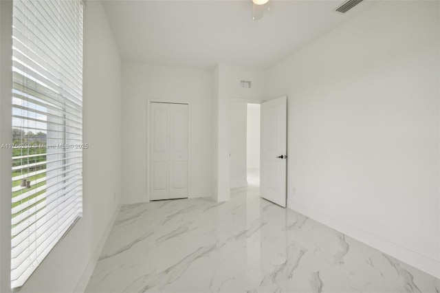 spare room with baseboards, visible vents, and marble finish floor