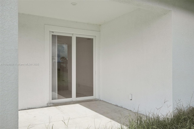 exterior space with stucco siding and a patio