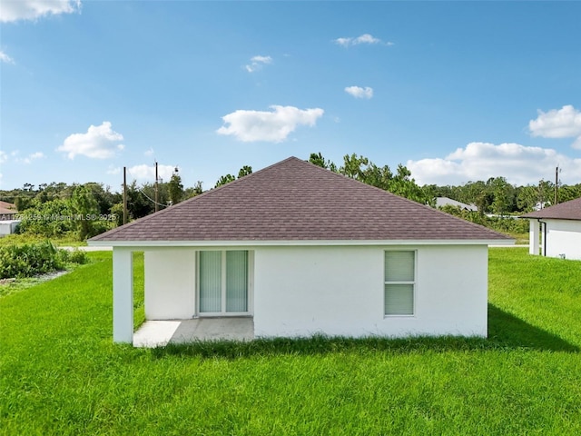 view of home's exterior featuring a shingled roof, a yard, and stucco siding