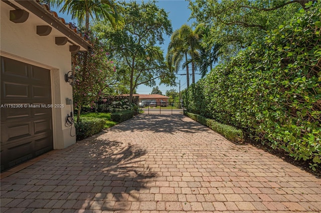 exterior space featuring decorative driveway and fence