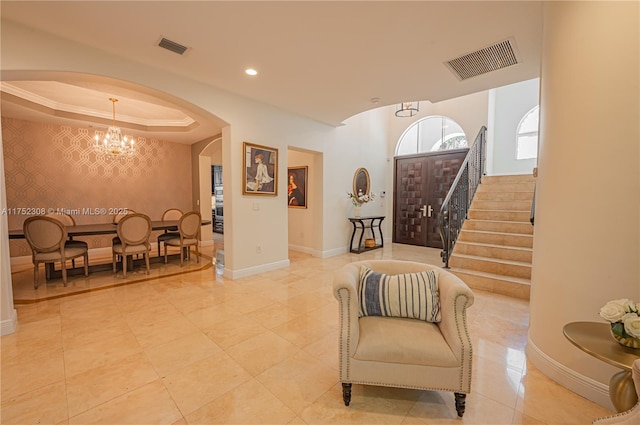 interior space with baseboards, arched walkways, visible vents, and a chandelier