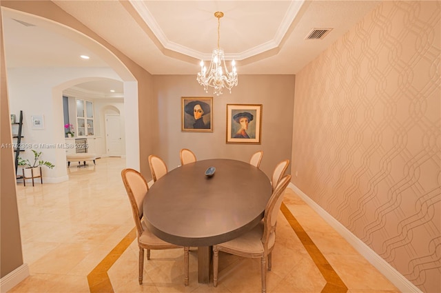 dining room featuring visible vents, baseboards, wallpapered walls, a tray ceiling, and an accent wall