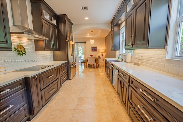 kitchen with visible vents, recessed lighting, appliances with stainless steel finishes, arched walkways, and wall chimney exhaust hood