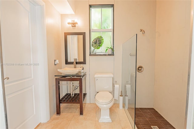 full bathroom featuring toilet, walk in shower, vanity, and tile patterned flooring