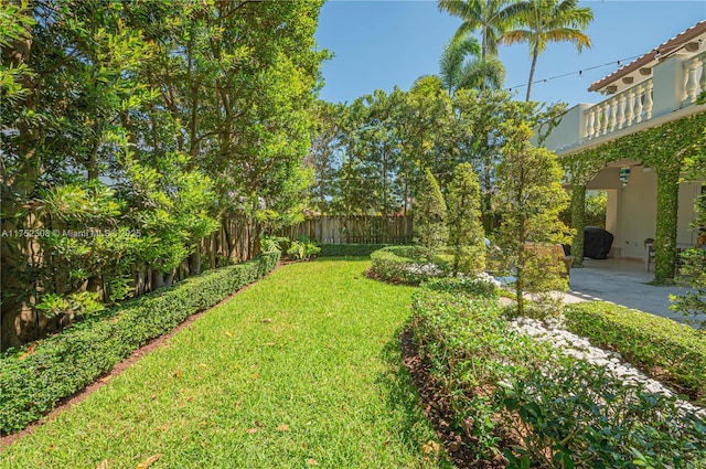 view of yard featuring a balcony, a patio, and fence