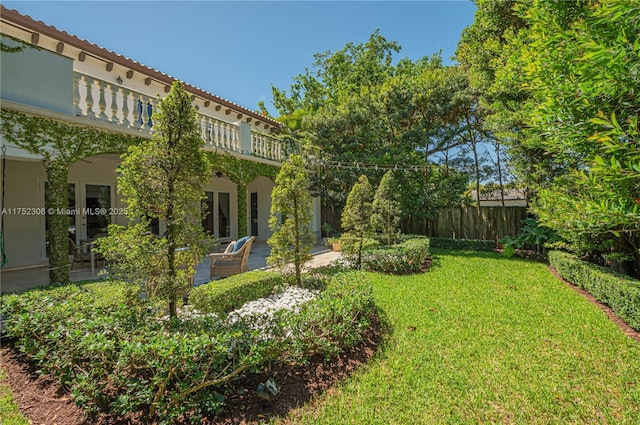 view of yard featuring a balcony, a patio, and fence