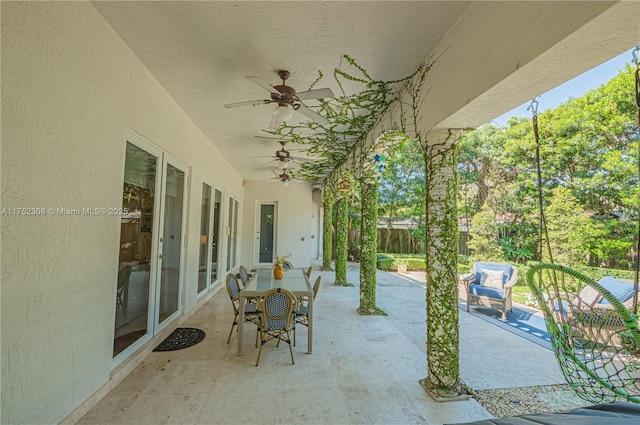 view of patio with outdoor dining area, ceiling fan, and fence