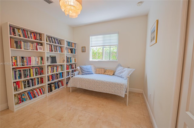 living area featuring tile patterned floors, baseboards, and a notable chandelier