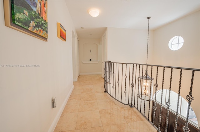 corridor with light tile patterned floors and baseboards