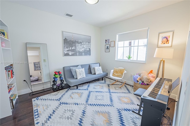 living area with visible vents, baseboards, and wood finished floors