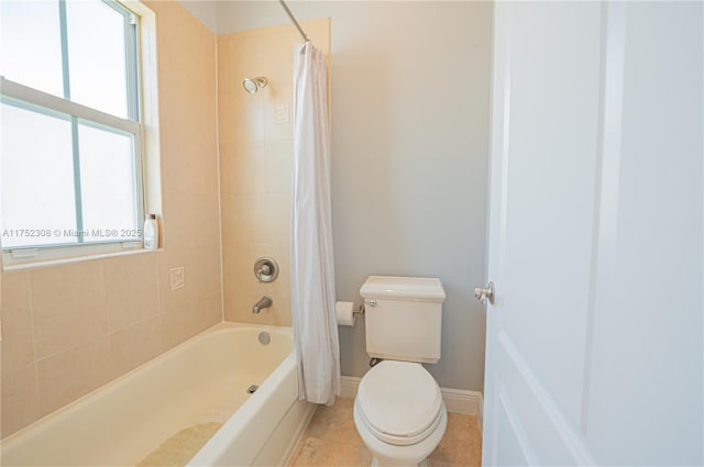 bathroom featuring tile patterned floors, baseboards, toilet, and shower / bath combination with curtain