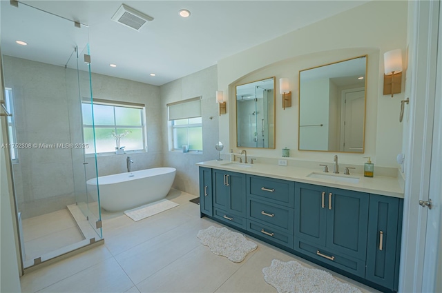 bathroom featuring visible vents, a stall shower, a freestanding bath, and a sink