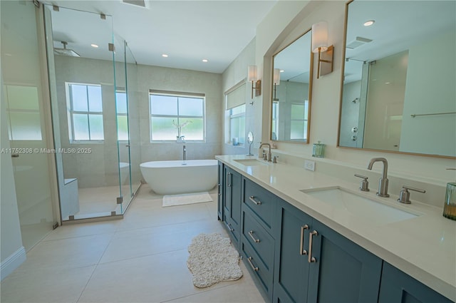 bathroom with tile patterned flooring, a soaking tub, a stall shower, and a sink