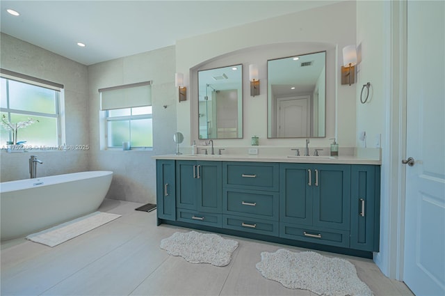 bathroom with a sink, visible vents, a soaking tub, and double vanity