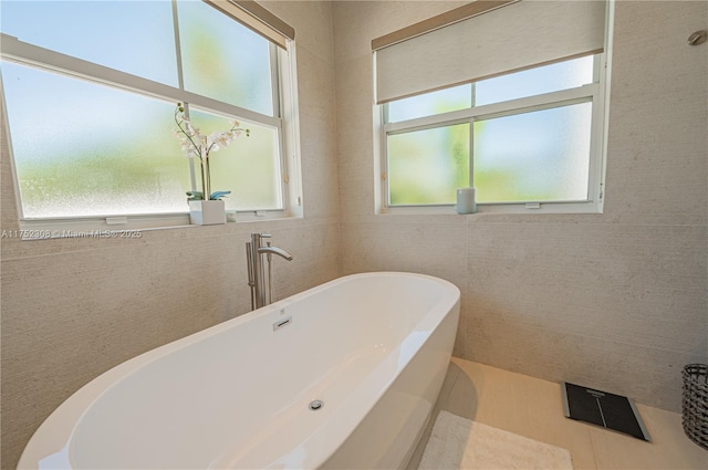 full bathroom with a freestanding bath and tile walls