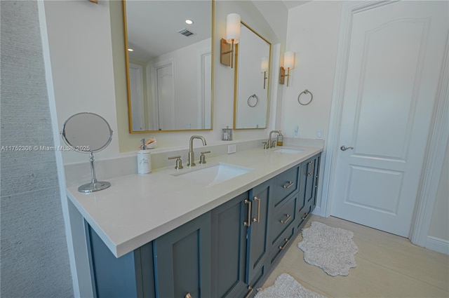 bathroom with double vanity, visible vents, and a sink