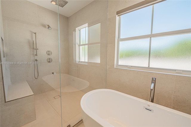 full bath with a soaking tub, a walk in shower, and tile walls