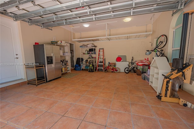 garage featuring stainless steel fridge with ice dispenser