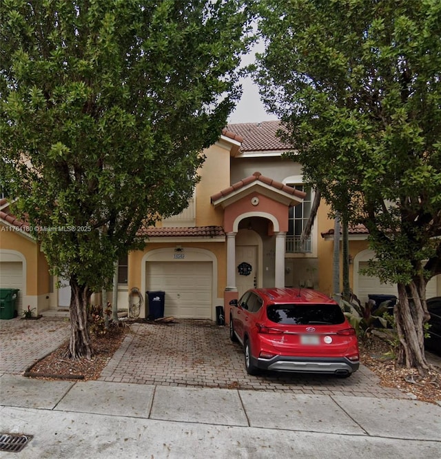 view of front of house with a tile roof, decorative driveway, and stucco siding