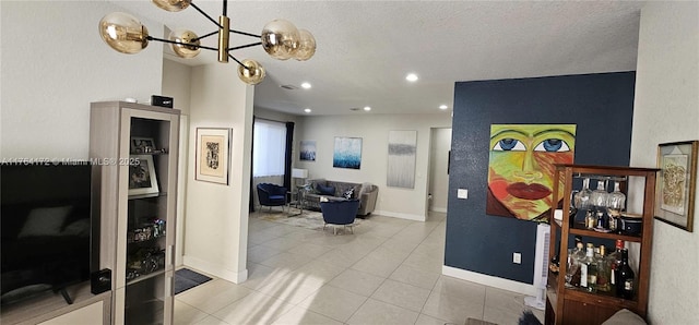 interior space with baseboards, an inviting chandelier, recessed lighting, a textured ceiling, and tile patterned floors