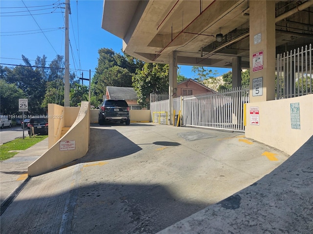 view of parking / parking lot with a gate and fence