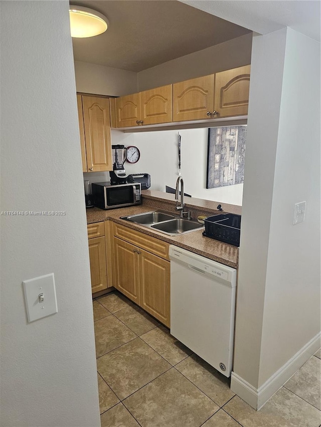 kitchen with light tile patterned flooring, a sink, stainless steel microwave, and white dishwasher