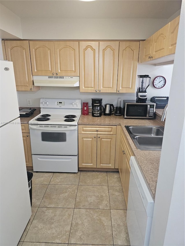 kitchen featuring light brown cabinetry, under cabinet range hood, a sink, white appliances, and light tile patterned floors