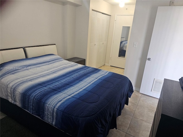 bedroom featuring a closet, visible vents, and light tile patterned flooring