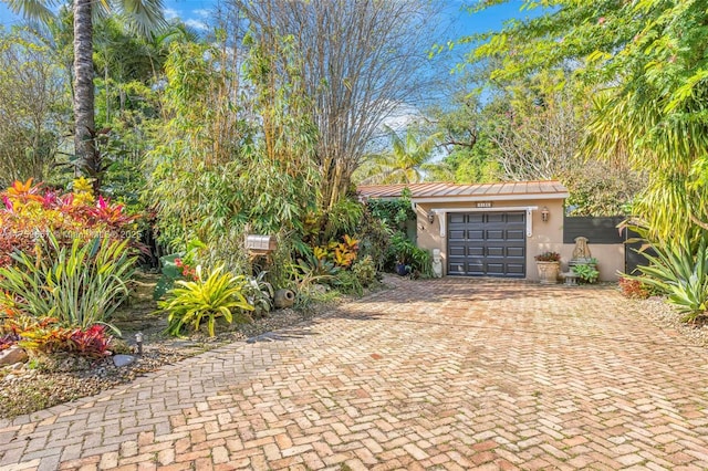 view of patio / terrace with an attached garage and decorative driveway