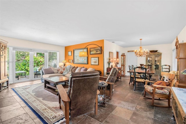 living room with a chandelier and stone tile flooring