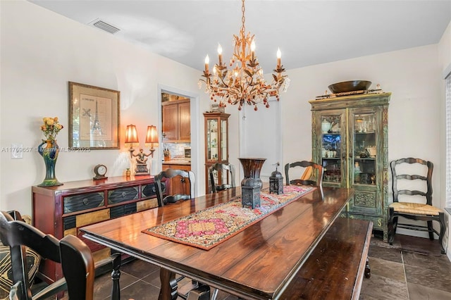 dining space with visible vents, a chandelier, and stone finish floor