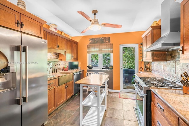 kitchen with brown cabinets, a sink, premium appliances, extractor fan, and ceiling fan