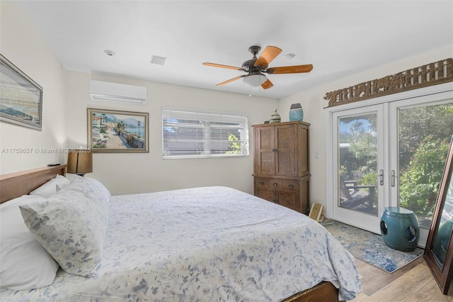 bedroom with ceiling fan, french doors, a wall mounted air conditioner, access to outside, and light wood-type flooring