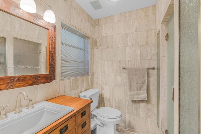 full bath with an enclosed shower, toilet, tile walls, and vanity