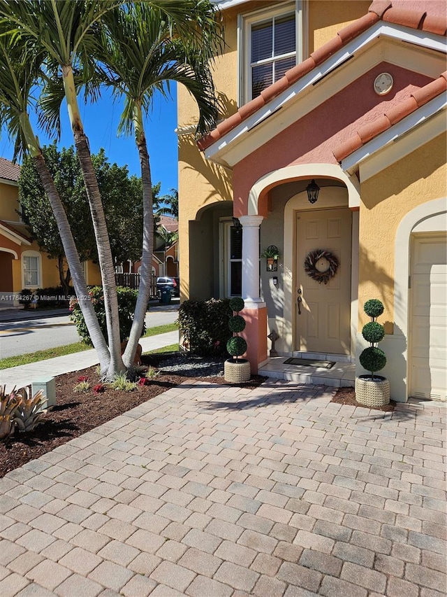 property entrance featuring stucco siding and a tiled roof