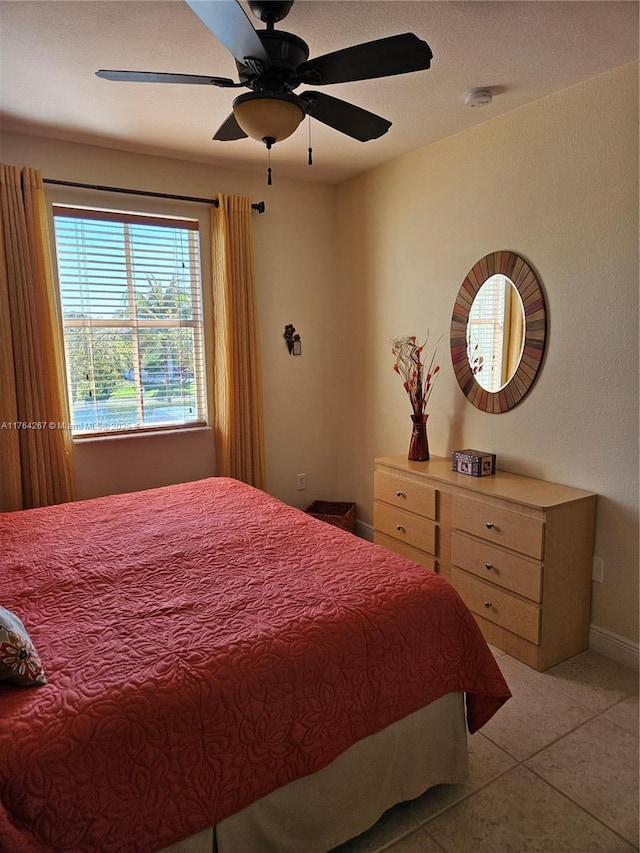 bedroom featuring light tile patterned flooring, baseboards, and a ceiling fan