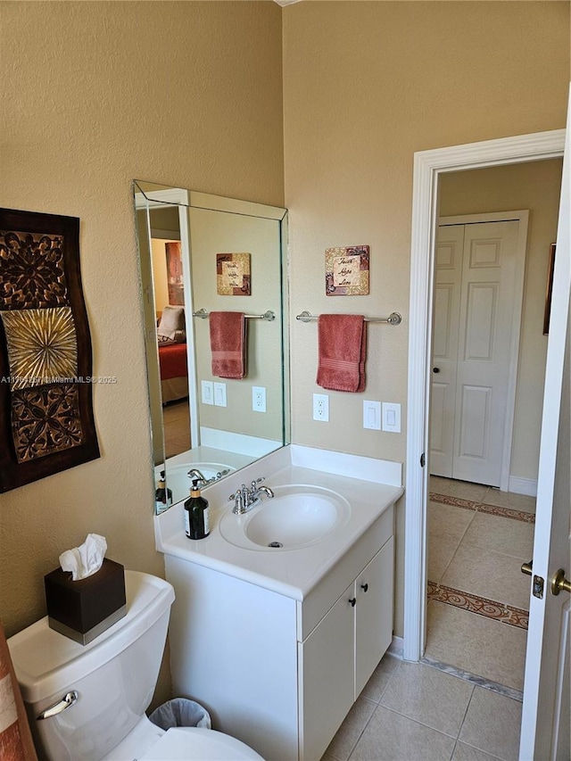 bathroom with vanity, toilet, and tile patterned flooring