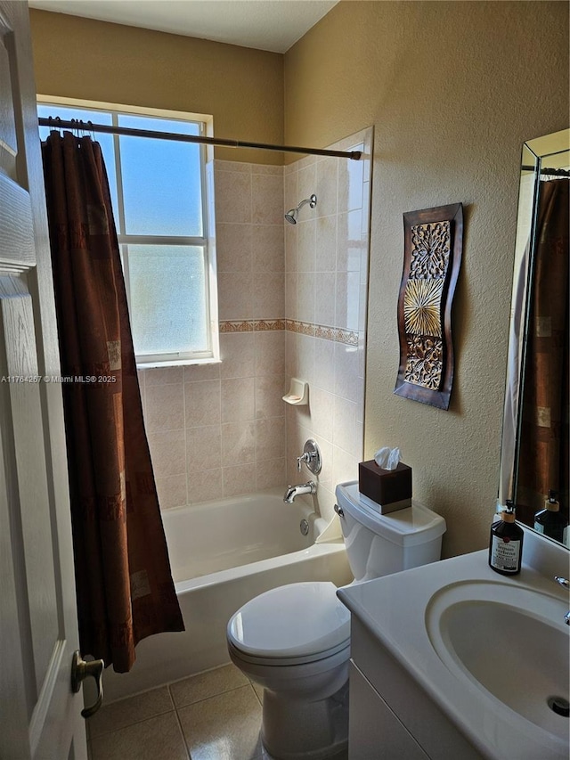 bathroom featuring tile patterned floors, toilet, shower / tub combo, vanity, and a textured wall