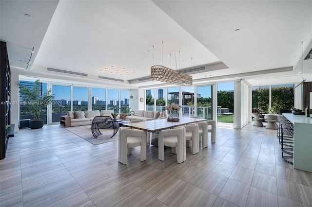 4701 N Meridian Ave Unit 603, Miami Beach, FL 33140 - dining space featuring light tile patterned flooring, a city view, a raised ceiling, and expansive windows
