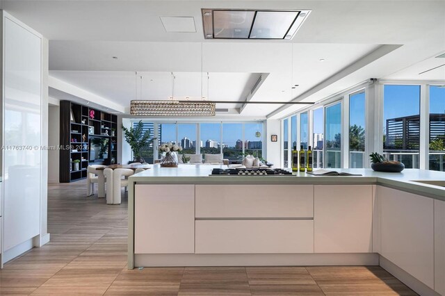 4701 N Meridian Ave Unit 603, Miami Beach, FL 33140 - kitchen with stainless steel gas cooktop, white cabinets, modern cabinets, and a wealth of natural light