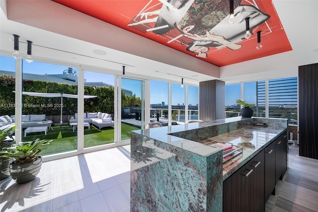 4701 N Meridian Ave Unit 603, Miami Beach, FL 33140 - kitchen featuring stone countertops, a kitchen island, and a raised ceiling